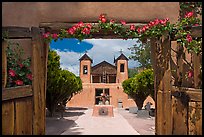 Church framed by doors with roses, Sanctuario de Chimayo. New Mexico, USA