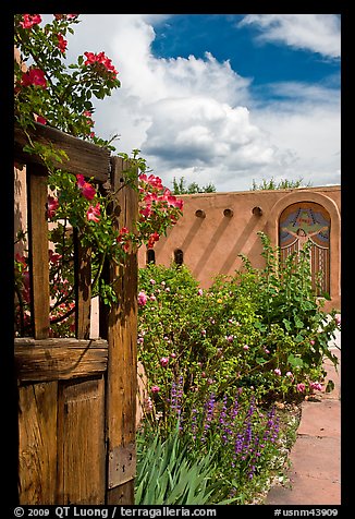 Gardens and adobe wall, Sanctuario de Chimayo. New Mexico, USA