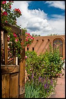 Gardens and adobe wall, Sanctuario de Chimayo. New Mexico, USA