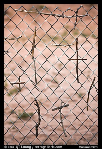 Crosses made of twigs on chain-link fence, Sanctuario de Chimayo. New Mexico, USA (color)