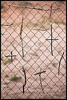 Crosses made of twigs on chain-link fence, Sanctuario de Chimayo. New Mexico, USA (color)