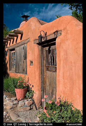 Flowers, adobe wall, and weathered door. Santa Fe, New Mexico, USA (color)