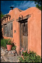 Flowers, adobe wall, and weathered door. Santa Fe, New Mexico, USA