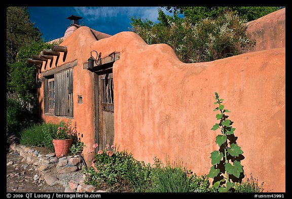 Adobe wall and weathered wooden door and window. Santa Fe, New Mexico, USA