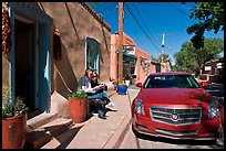 Couple reading art magazine in front of gallery. Santa Fe, New Mexico, USA ( color)