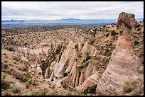 Tent rock with caprock overlooking mesa with distant Sangre de Cristo and Jemez Mountains. Kasha-Katuwe Tent Rocks National Monument, New Mexico, USA ( color)