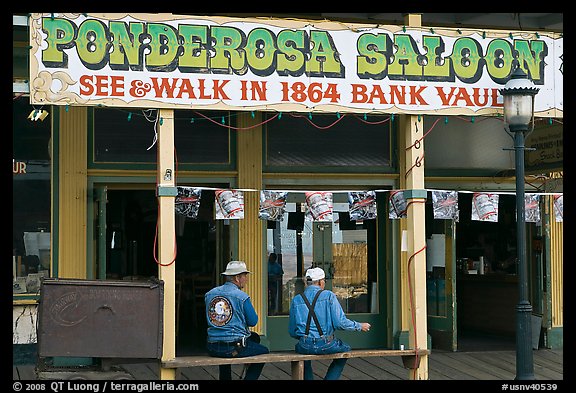 Men sitting on bench below Ponderosa Saloon sign. Virginia City, Nevada, USA (color)