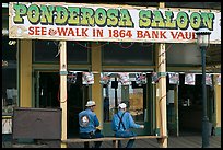 Men sitting on bench below Ponderosa Saloon sign. Virginia City, Nevada, USA