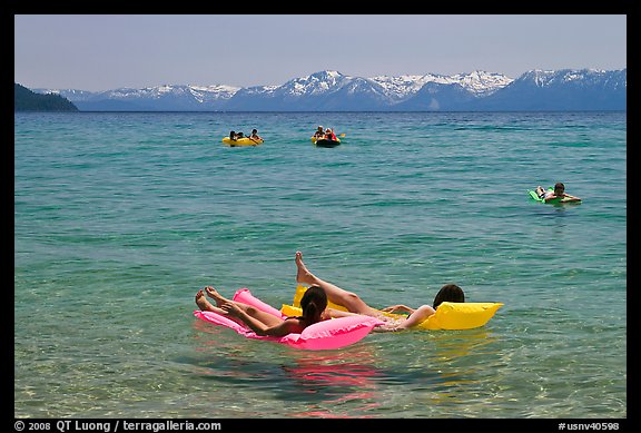 Children playing in water, and distant snowy mountains, Sand Harbor, Lake Tahoe, Nevada. USA