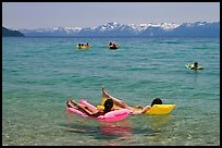 Children playing in water, and distant snowy mountains, Sand Harbor, Lake Tahoe, Nevada. USA