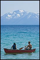 Man and woman in canoe with snowy mountains in the background, Lake Tahoe, Nevada. USA (color)