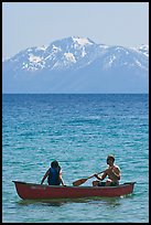 Man and woman in canoe with snowy mountains in the background, Lake Tahoe, Nevada. USA