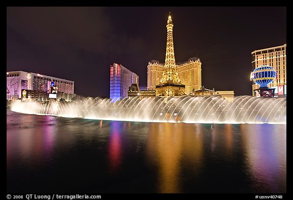 Bellagio dancing fountains and hotels reflected in lake. Las Vegas, Nevada, USA