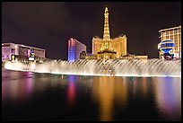 Bellagio dancing fountains and hotels reflected in lake. Las Vegas, Nevada, USA