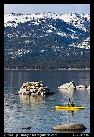 Kayaker with backdrop of snow-covered mountains, Lake Tahoe-Nevada State Park, Nevada. USA (color)