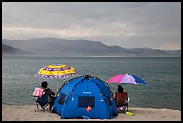 People with tent and beach umbrellas, approaching storm. Pyramid Lake, Nevada, USA (color)