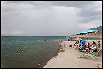 People lounging with beach chairs and umbrellas. Pyramid Lake, Nevada, USA ( color)