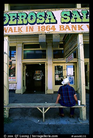 Man with cowboy hat sitting in front of a casino. Virginia City, Nevada, USA (color)