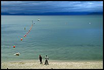 Men standing on beach under dark sky, South Lake Tahoe, California. USA