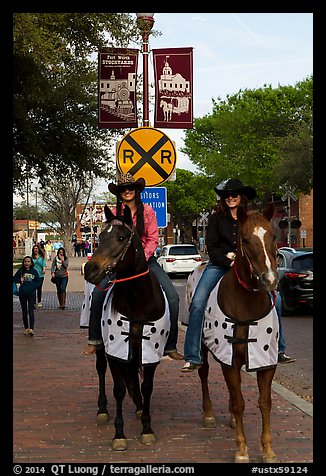 Women riding horses on sidewalk, Stockyards. Fort Worth, Texas, USA (color)