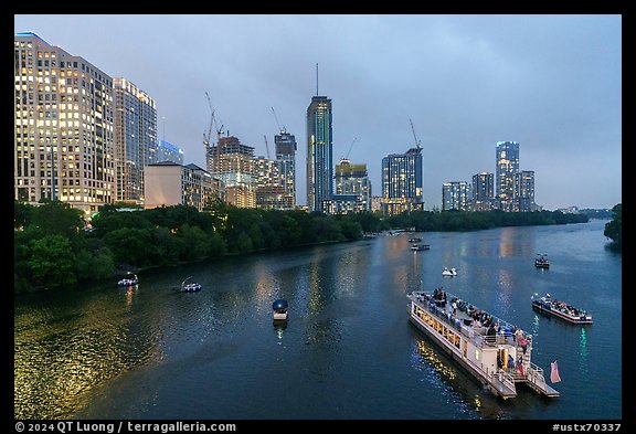 Skyline and tour boats on Colorado River at dusk. Austin, Texas, USA (color)