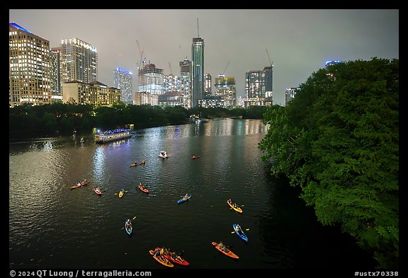 Skyline and kayaks on Colorado River at night. Austin, Texas, USA (color)
