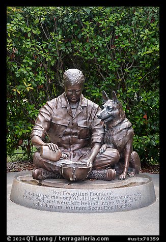 Bronze sculpture depicting Vietnam War dog handler pouring water from canteen into helmet, Military Working Dog Teams National Monument. San Antonio, Texas, USA (color)