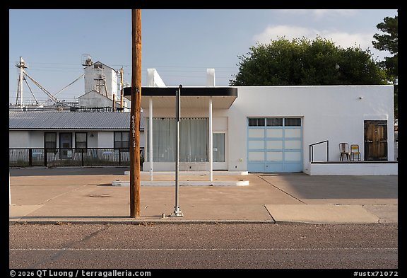 Minimalist white facade, grain elevators beyond, Marfa. Texas, USA (color)