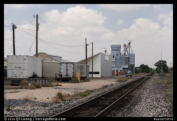 Railroad tracks past grain elevators and utility poles, Marfa. Texas, USA (color)