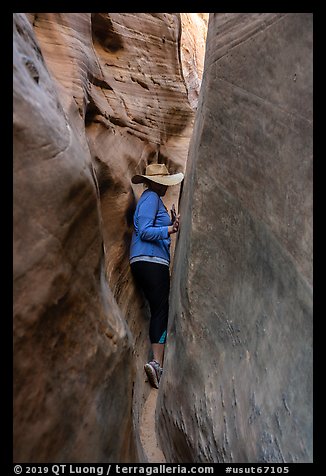Woman squeezing in Zebra Slot Canyon. Grand Staircase Escalante National Monument, Utah, USA (color)