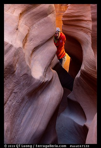 Man inside Peek-a-Boo slot canyon. Grand Staircase Escalante National Monument, Utah, USA (color)