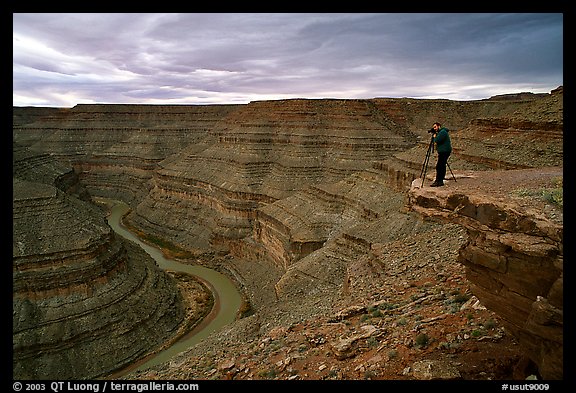 Photographer on overhang above the San Juan River, Goosenecks of the San Juan State Park. Utah, USA