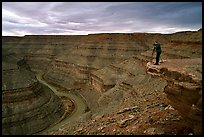 Photographer on overhang above the San Juan River, Goosenecks of the San Juan State Park. Bears Ears National Monument, Utah, USA ( color)