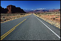Road, sandstone cliffs, snowy mountains. Utah, USA