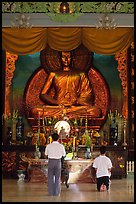 Men worshipping in front of a large Buddha state, Xa Loi pagoda, district 3. Ho Chi Minh City, Vietnam (color)