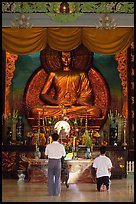 Men worshipping in front of a large Buddha state, Xa Loi pagoda, district 3. Ho Chi Minh City, Vietnam