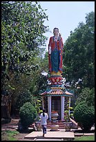 Woman praying under a large buddhist statue. Ho Chi Minh City, Vietnam (color)