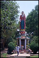 Woman praying under a large buddhist statue. Ho Chi Minh City, Vietnam