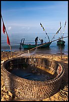 Fishermen pulling net out of circular basket. Phu Quoc Island, Vietnam ( color)