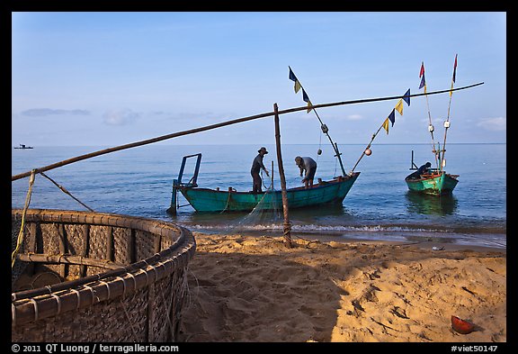 Fishermen pulling net onto skiff. Phu Quoc Island, Vietnam