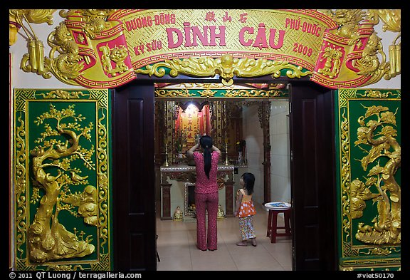 Woman with girl worshipping at Dinh Cau temple, Duong Dong. Phu Quoc Island, Vietnam (color)