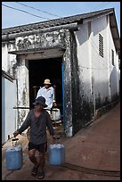 Workers carrying out containers of nuoc mam, Duong Dong. Phu Quoc Island, Vietnam ( color)