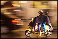 Women riding scooter in the rain. Ho Chi Minh City, Vietnam (color)