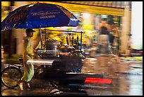 Man riding riding food cart in the rain. Ho Chi Minh City, Vietnam (color)