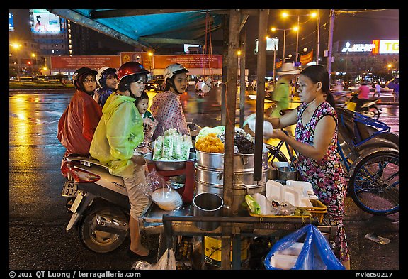 Women riding motorbikes buy sweet rice. Ho Chi Minh City, Vietnam