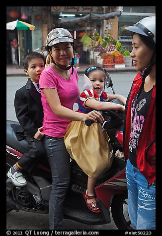 Woman riding with children. Ho Chi Minh City, Vietnam