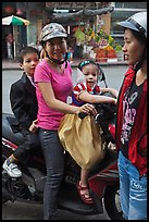 Woman riding with children. Ho Chi Minh City, Vietnam (color)