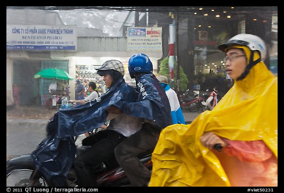 Motorcycle riders during afternoon mooson. Ho Chi Minh City, Vietnam (color)