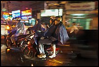 Motorcyle riders at night, dressed for the rain. Ho Chi Minh City, Vietnam (color)