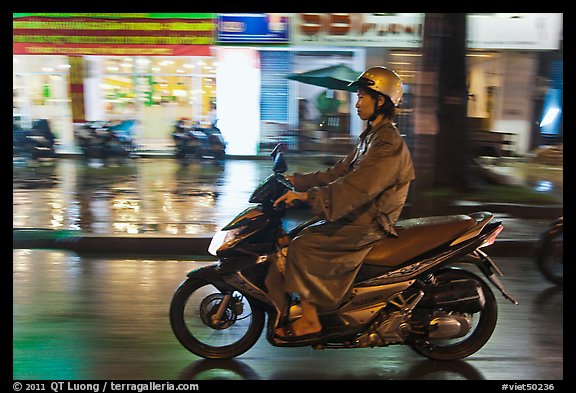 Riding motorcyle on rainy night. Ho Chi Minh City, Vietnam (color)